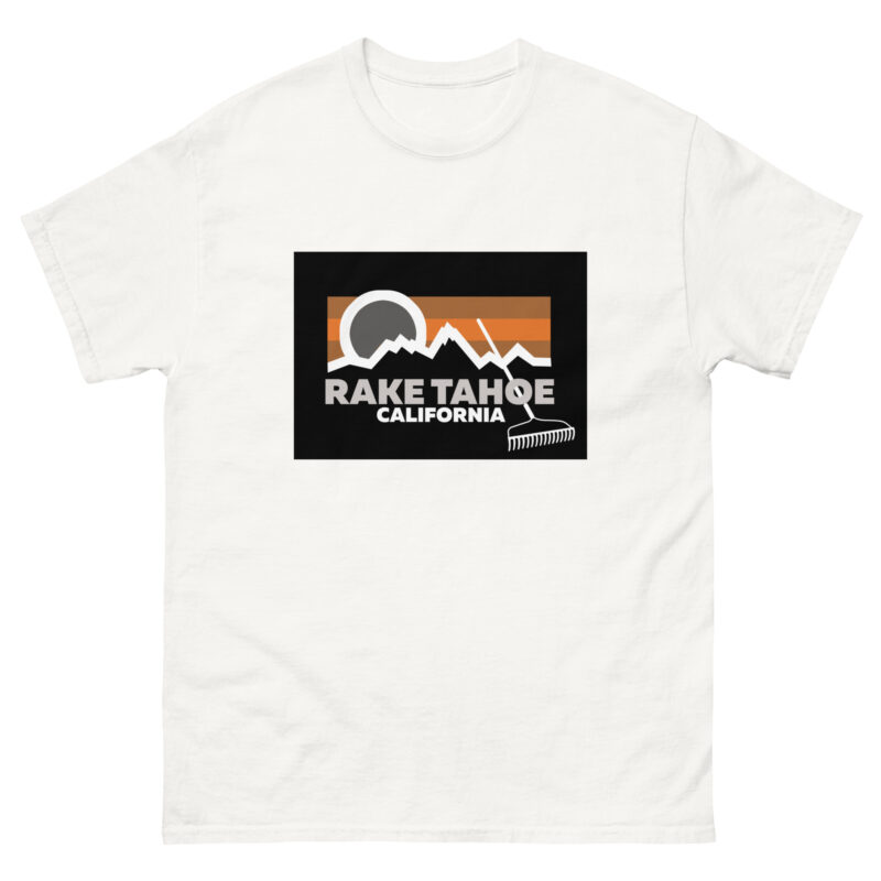 The Rake Tahoe product features a white t-shirt adorned with stylized mountains, a sun, and the text "Rake Tahoe, California," enhanced by an orange and black color palette and includes a small rake icon at the bottom of this distinct creative t.shirt design.