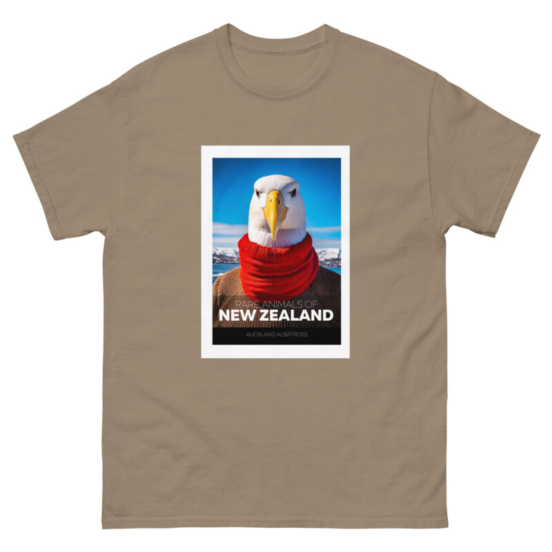 A tan T-shirt showcases a stylized depiction of an albatross adorned with a red scarf set against a blue sky backdrop. The text reads RARE ANIMALS OF NEW ZEALAND and AUCKLAND ALBATROSS.